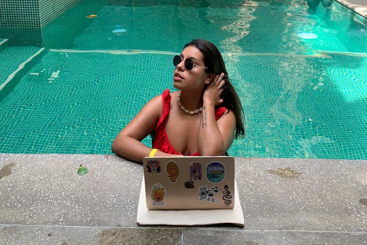 mujer trabajando con un computador en medio de una piscina
