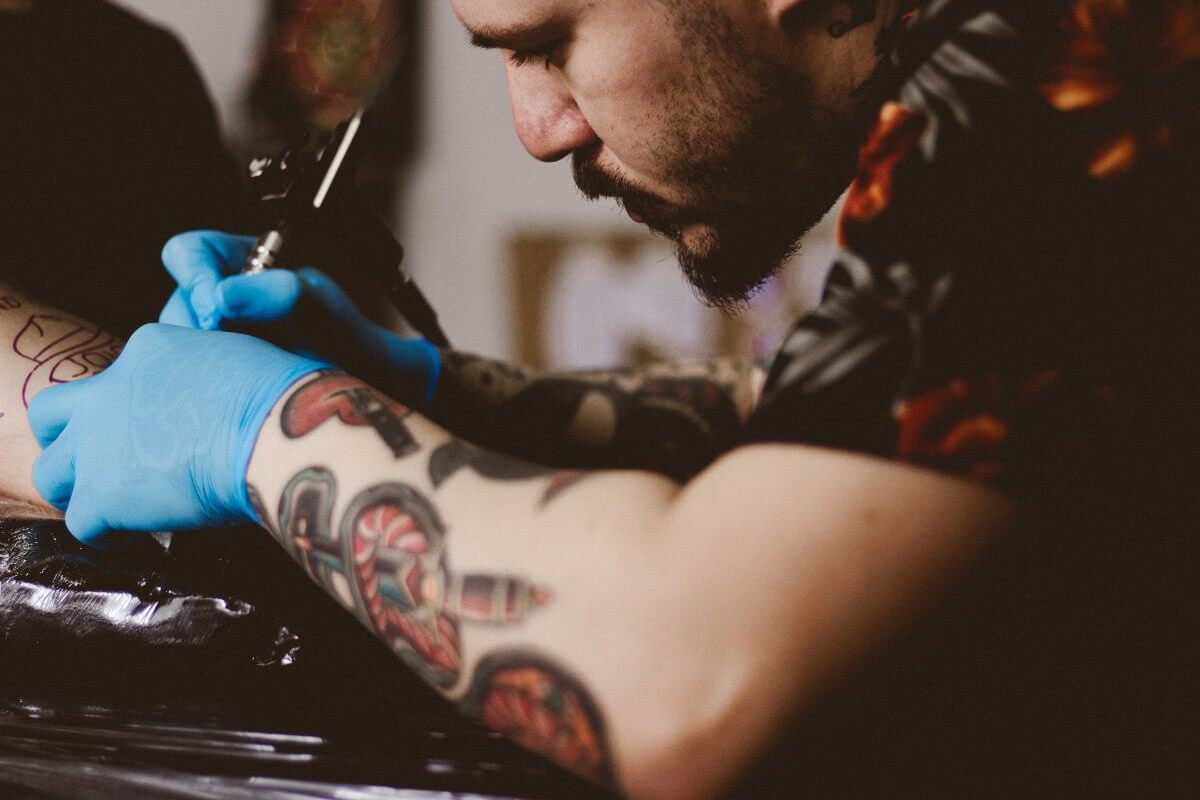 hombre joven tatuando un brazo